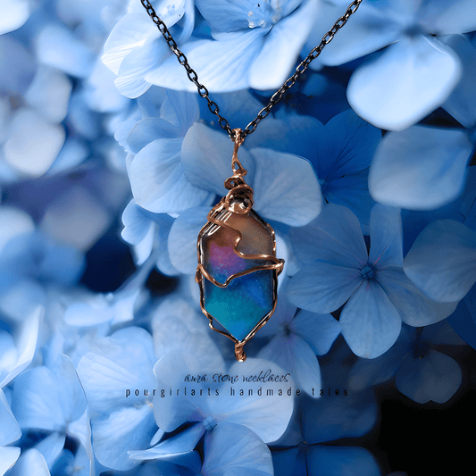 Colorful pendant necklace on a chain against a background of blue flowers