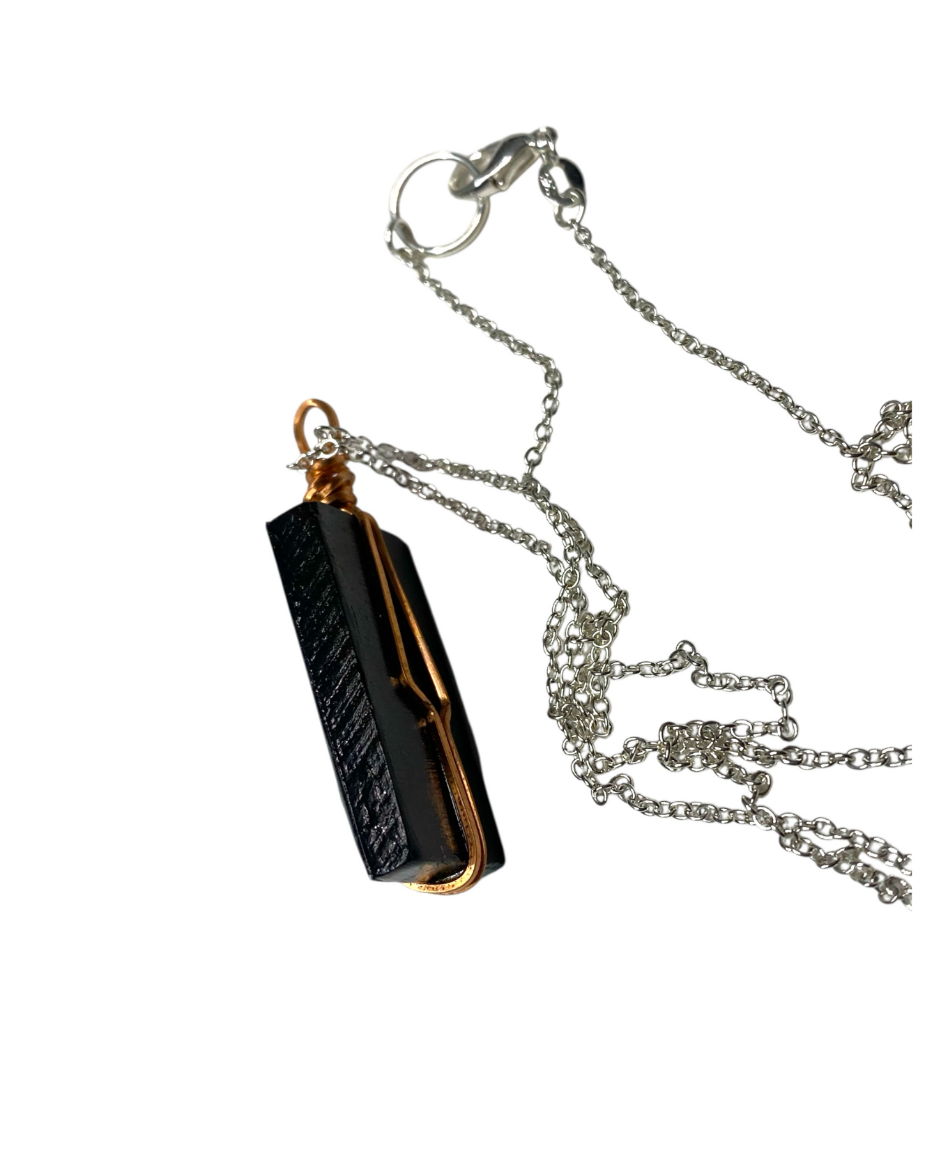 Black and gold pendant on a chain against a white background