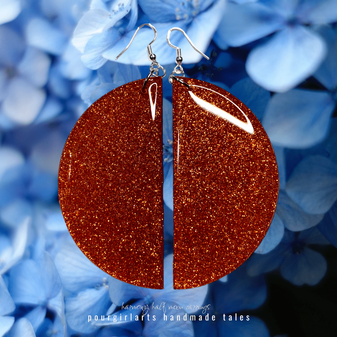 Bronze glittery earrings with silver hooks on a blue floral background