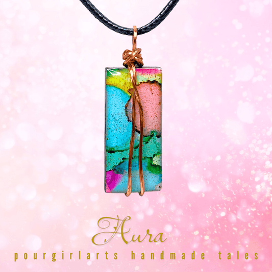 Colorful pendant necklace on a pink background with 'Aura pourgirlarts handmade tales' text.