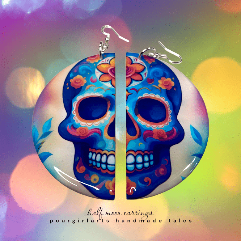 Colorful skull-shaped earrings with floral designs on a colorful blurred background.