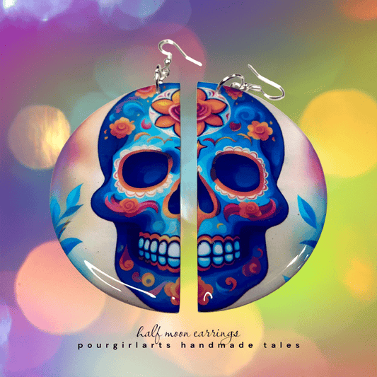 Colorful skull-shaped earrings with floral designs on a colorful blurred background.