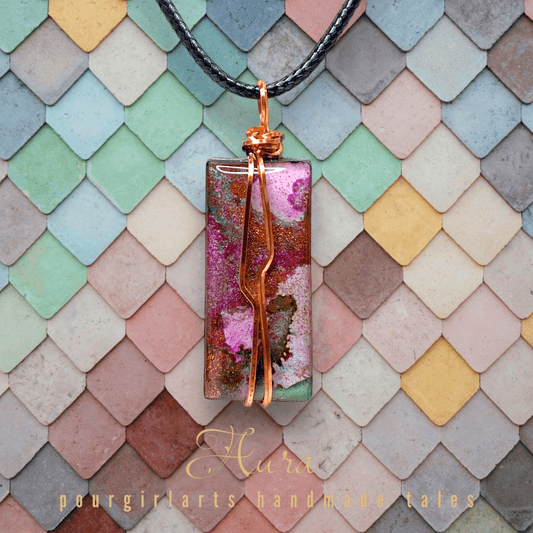 Colorful pendant necklace on a patterned background with 'Hura' branding.
