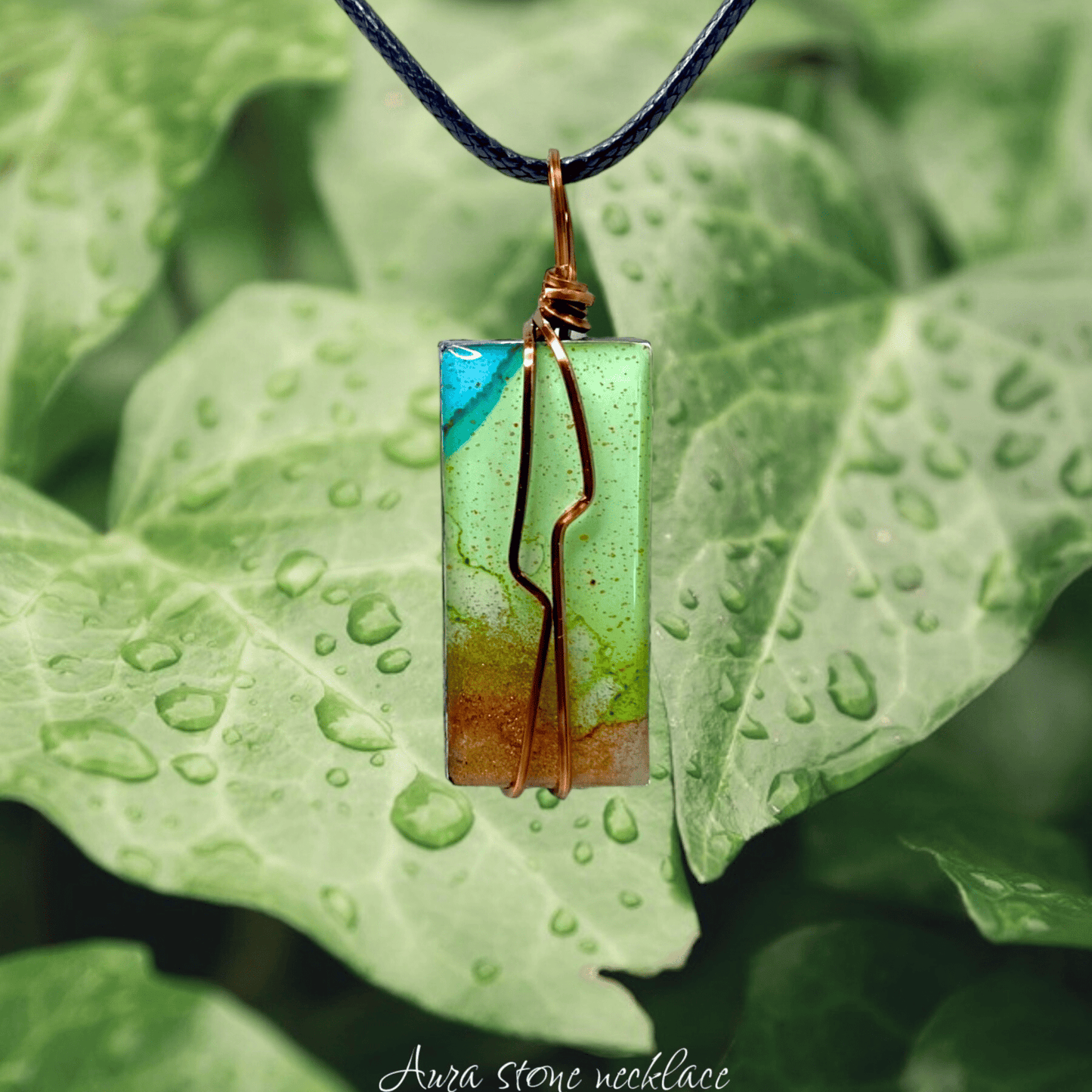 Green stone necklace with copper wire on a leaf background