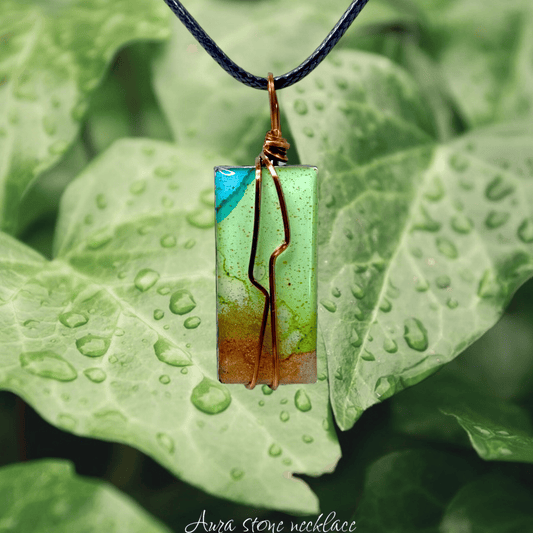 Green stone necklace with copper wire on a leaf background