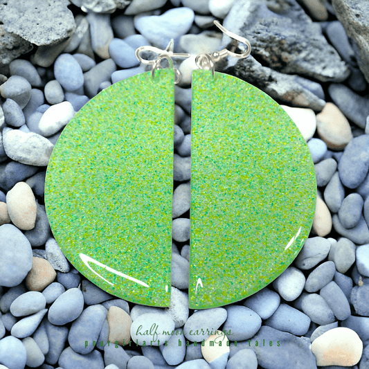 Green speckled earrings on a pebble background