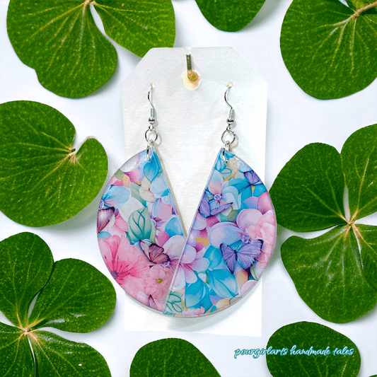 Colorful floral teardrop earrings on a white card with green leaves around