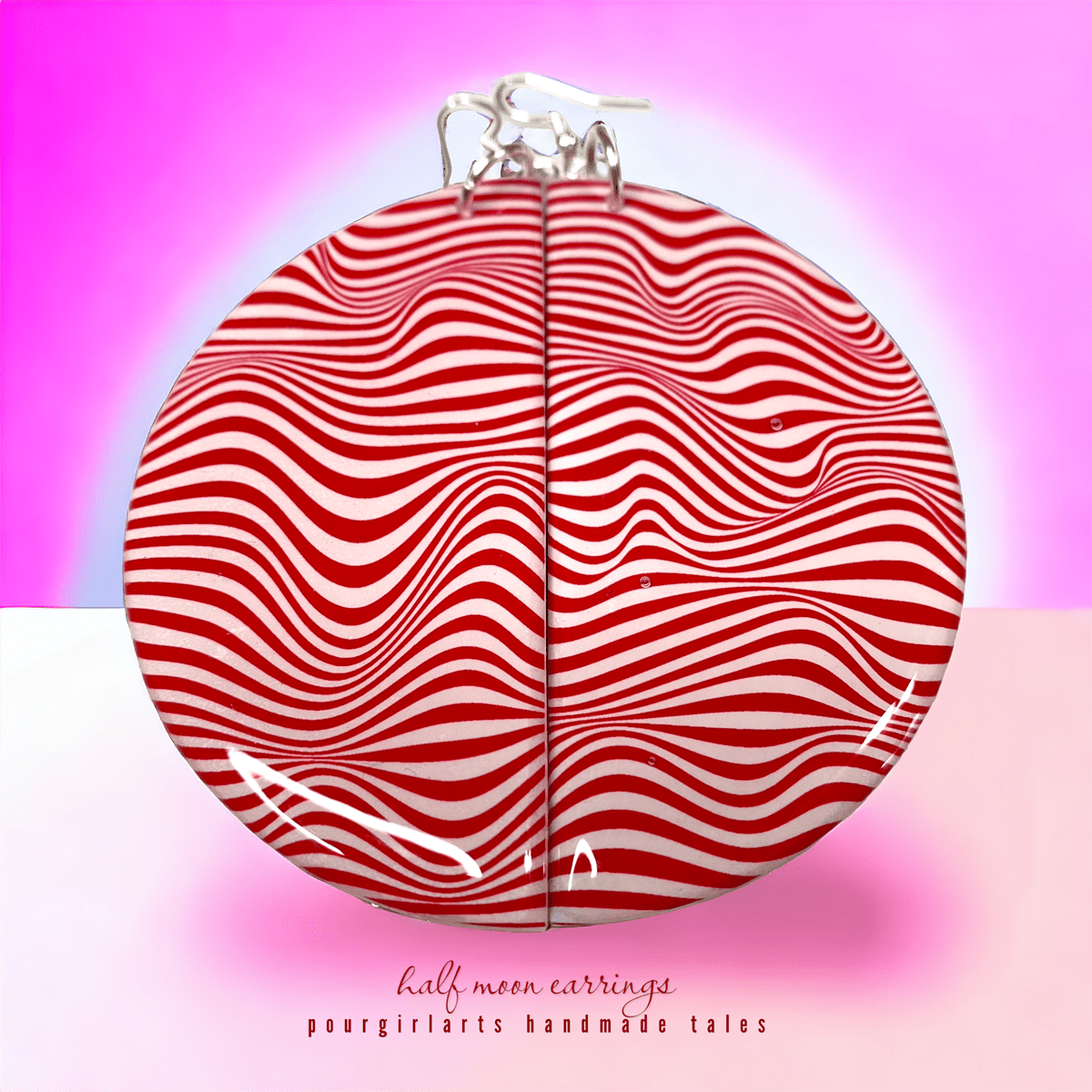 Red and white striped earrings on a pink background