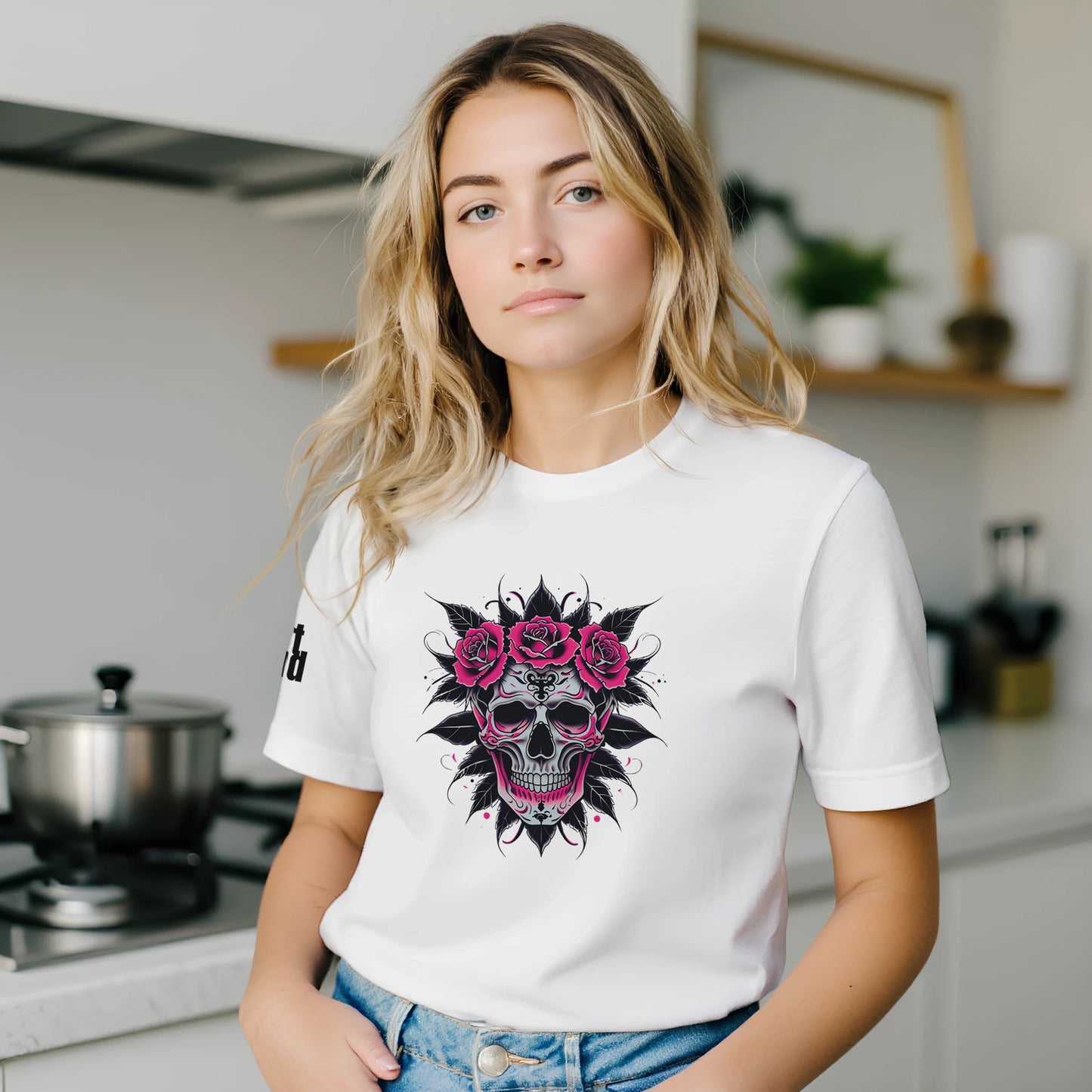 Woman wearing a white t-shirt with a skull and roses design in a kitchen.