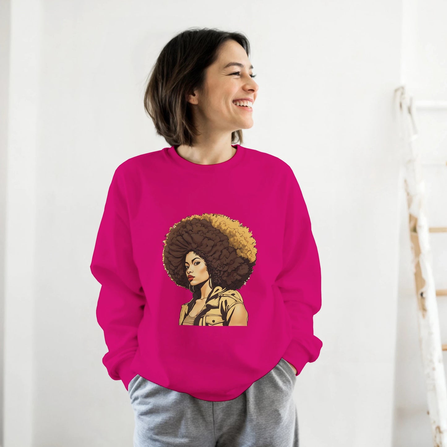 Person wearing a pink sweatshirt with a graphic design of a woman with an afro on a white background