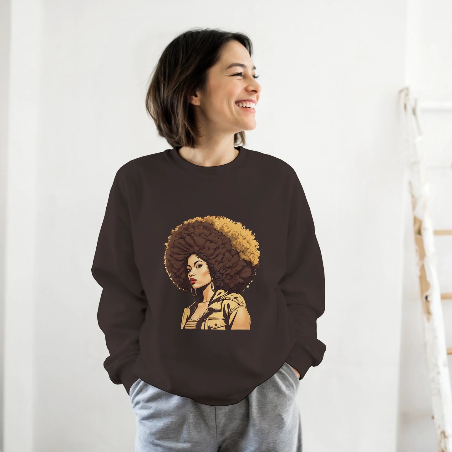 Person wearing a brown sweatshirt with a graphic design of a woman with an afro on a white background