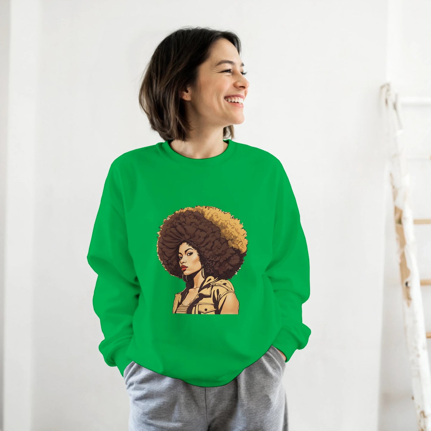 Person wearing a green sweatshirt with a graphic design of a woman with an afro on a white background