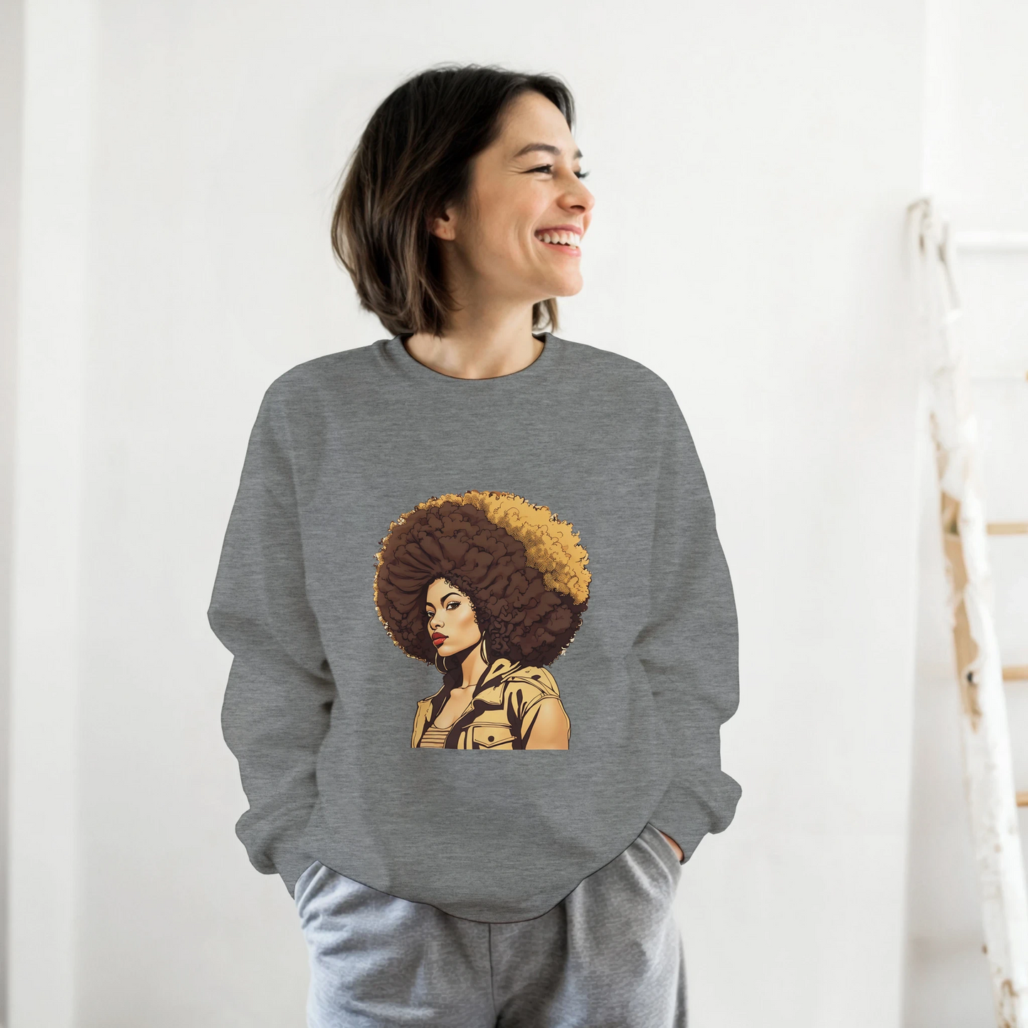Person wearing a gray sweatshirt with a graphic design of a woman with an afro on a white background