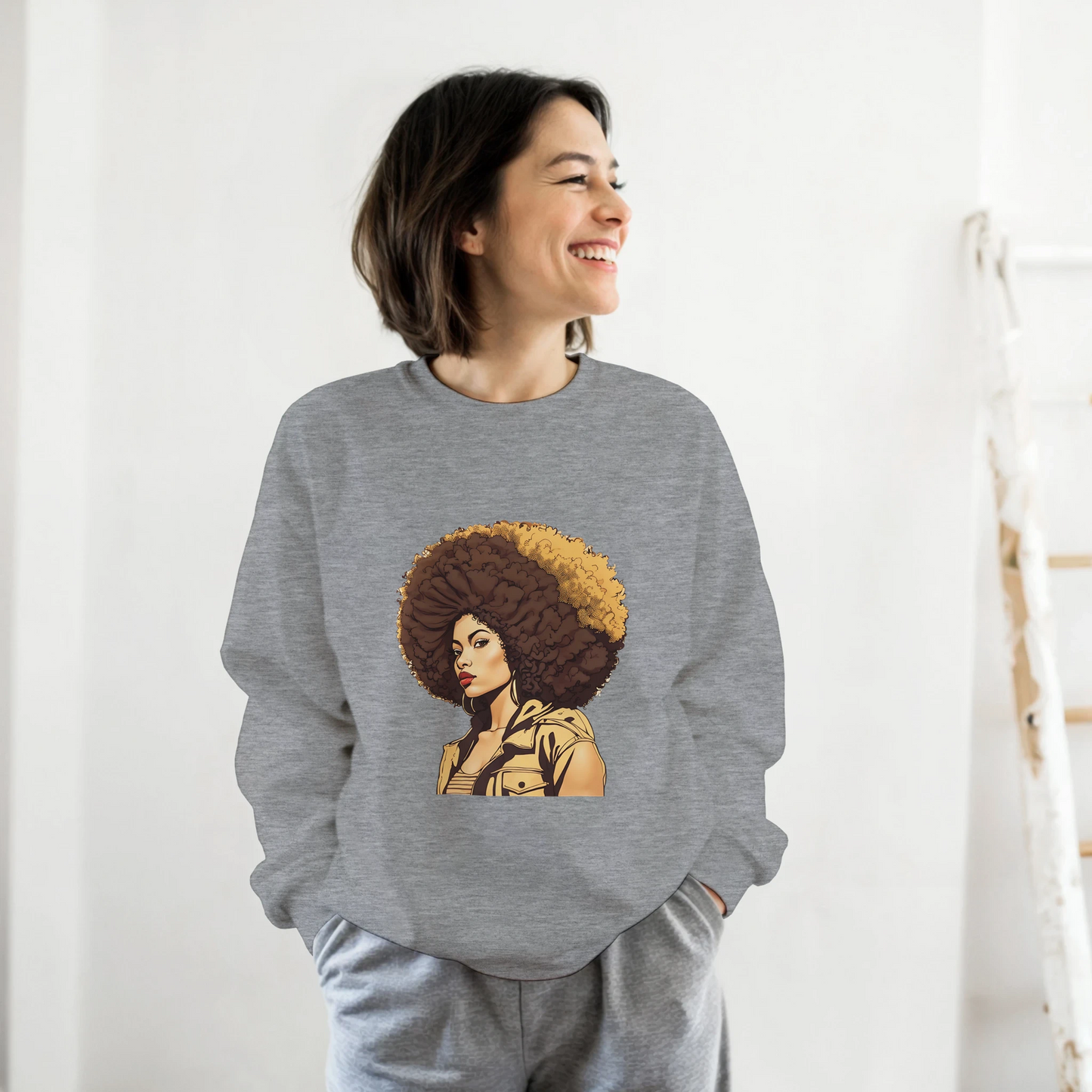 Person wearing a gray sweatshirt with a graphic design of a woman with an afro on a white background