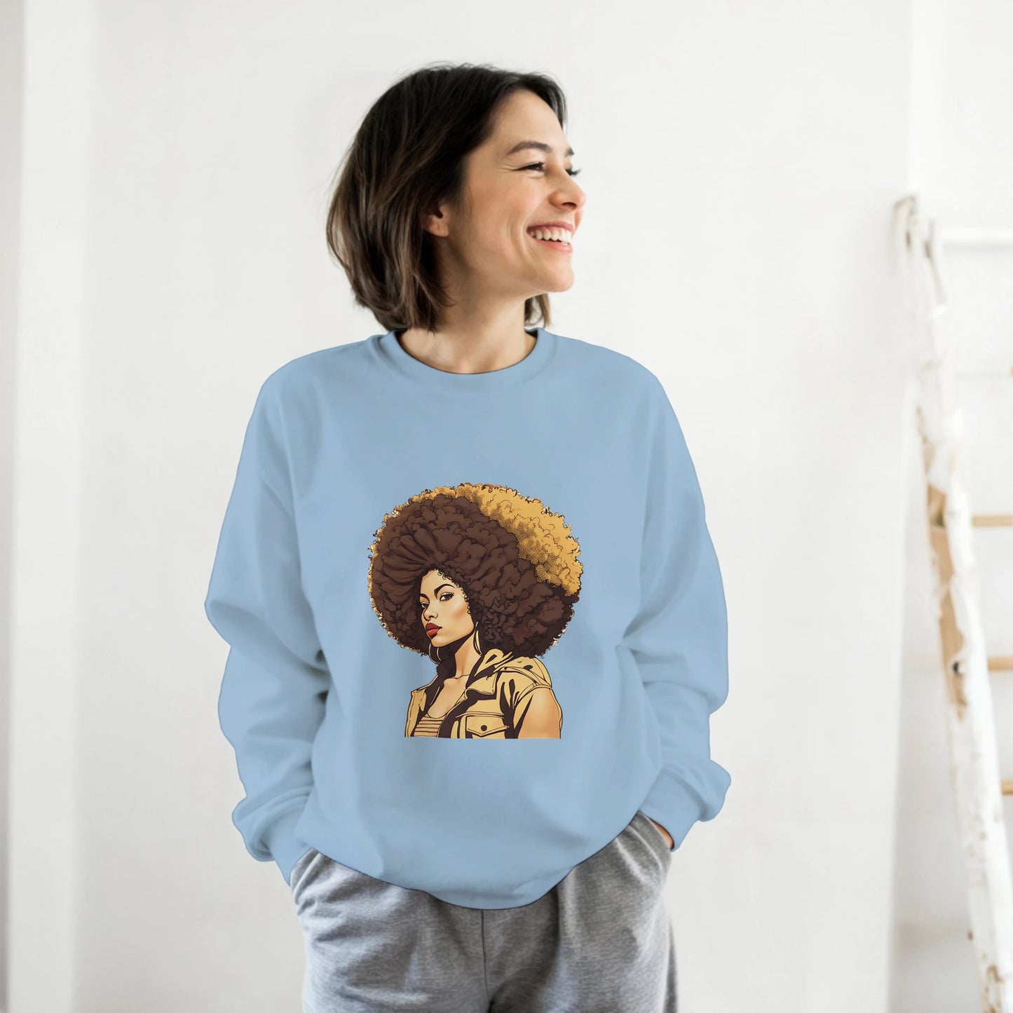 Person wearing a light blue sweatshirt with a graphic design of a woman with an afro.