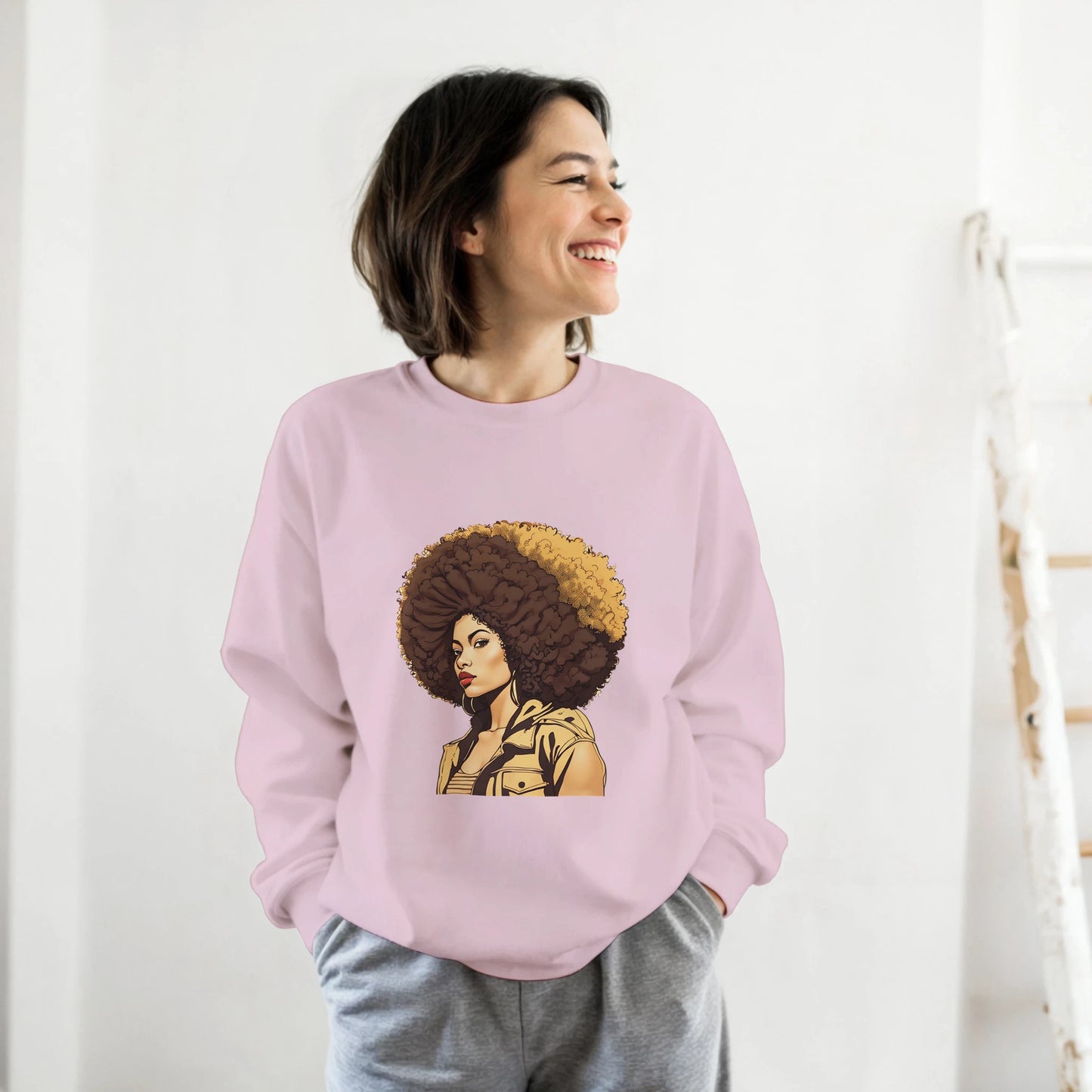 Person wearing a pink sweatshirt with a graphic design of a woman with an afro on a white background