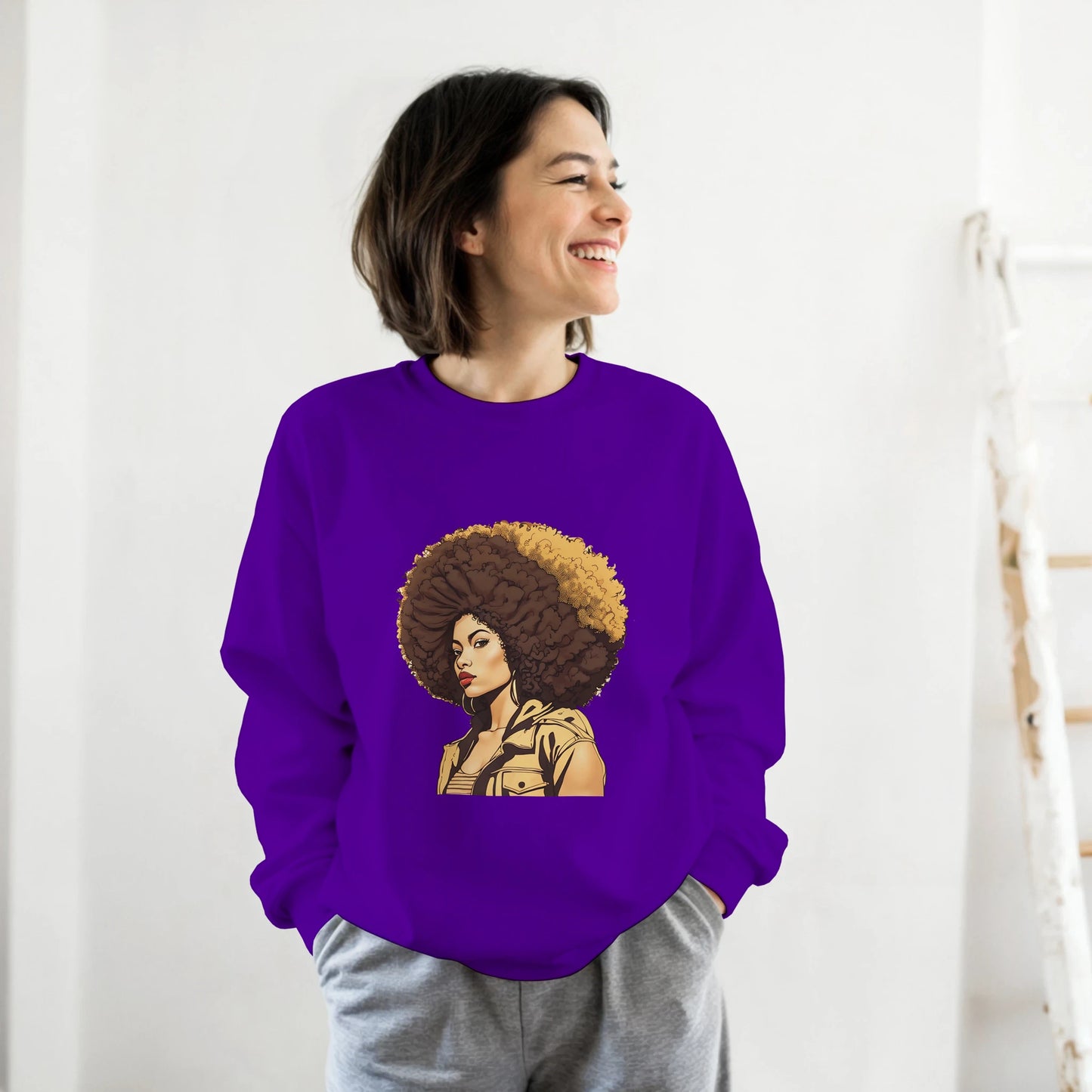 Person wearing a purple sweatshirt with a graphic design of a woman with an afro on a white background
