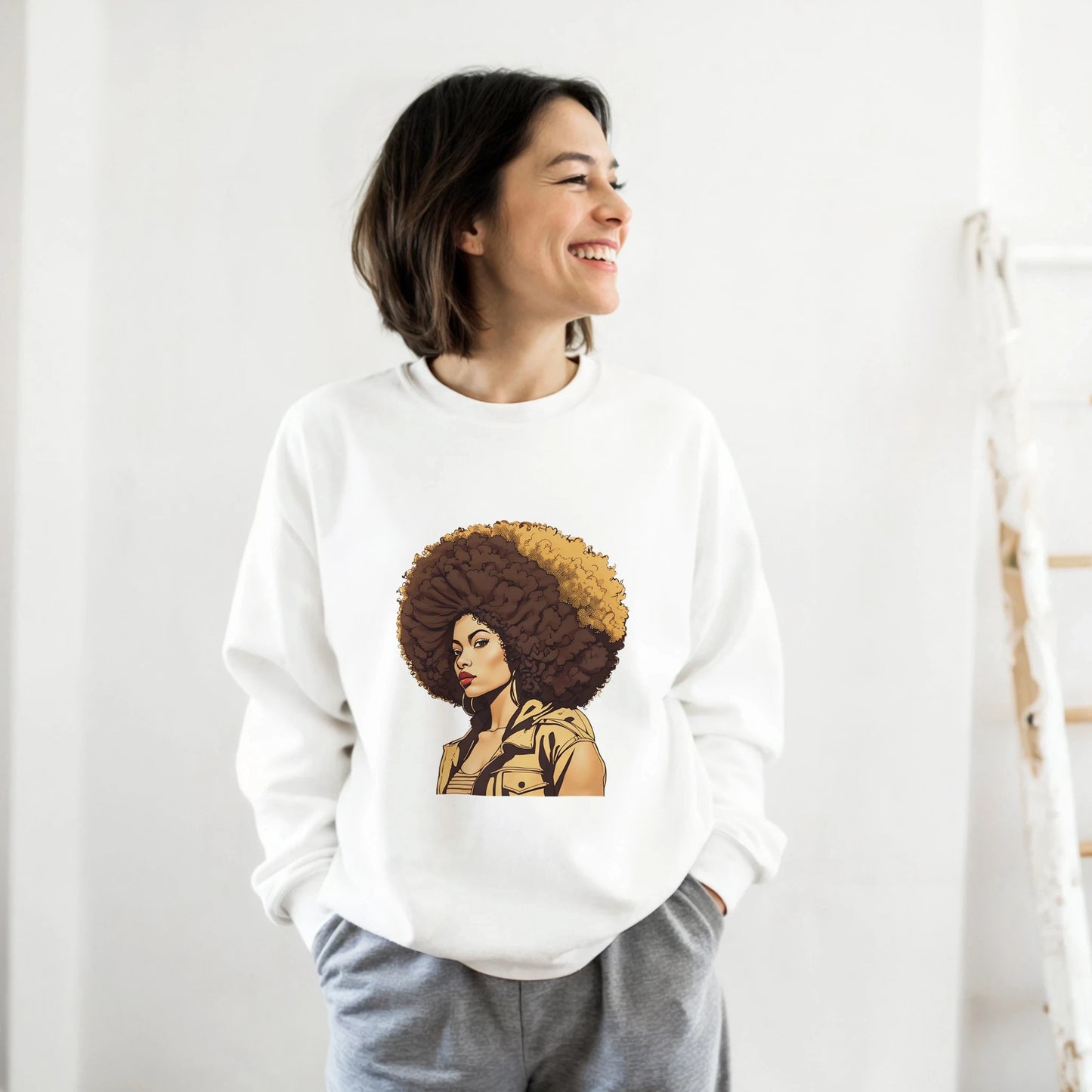 Person wearing a white sweatshirt with a graphic design of a person with an afro on a plain background
