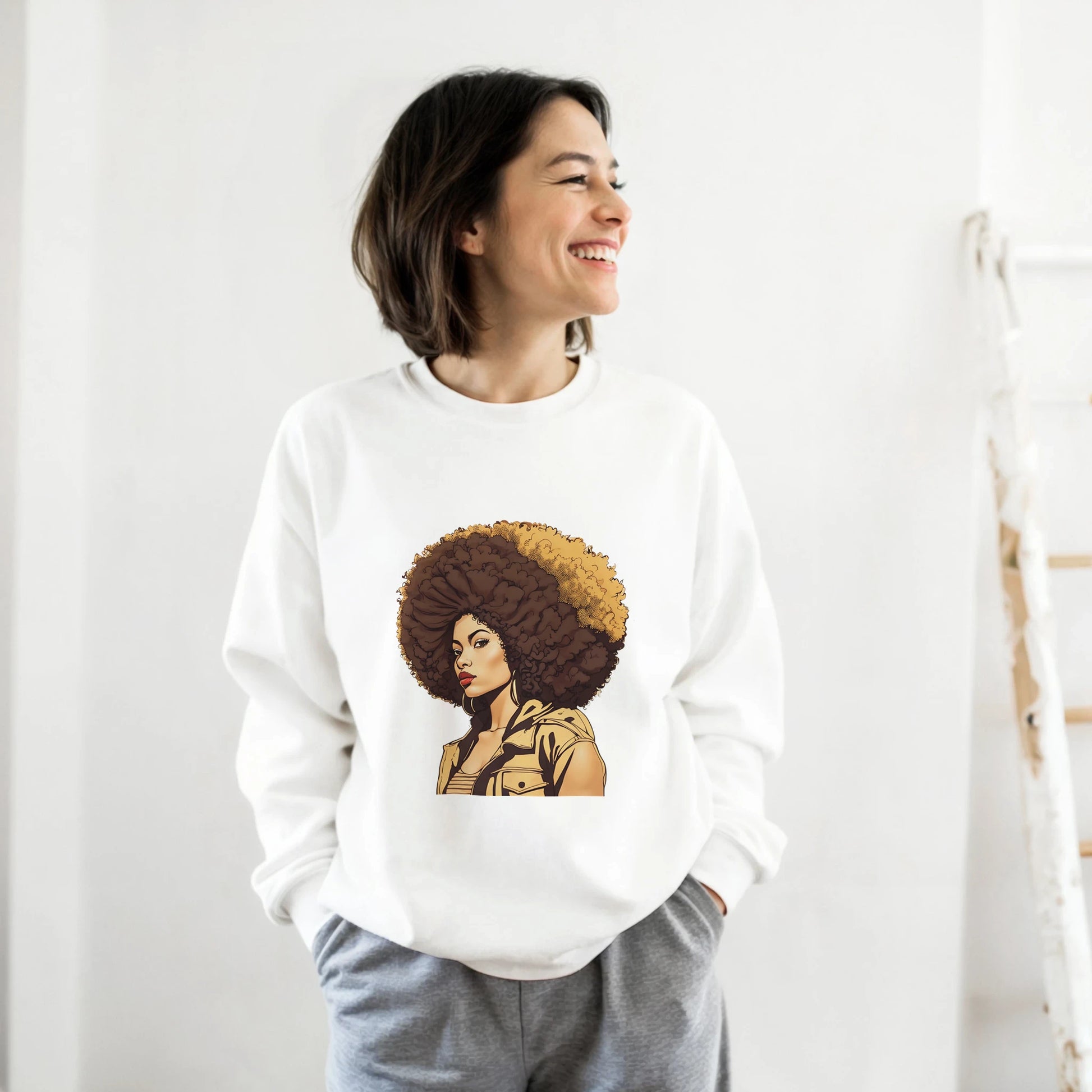 Person wearing a white sweatshirt with a graphic design of a person with an afro on a plain background
