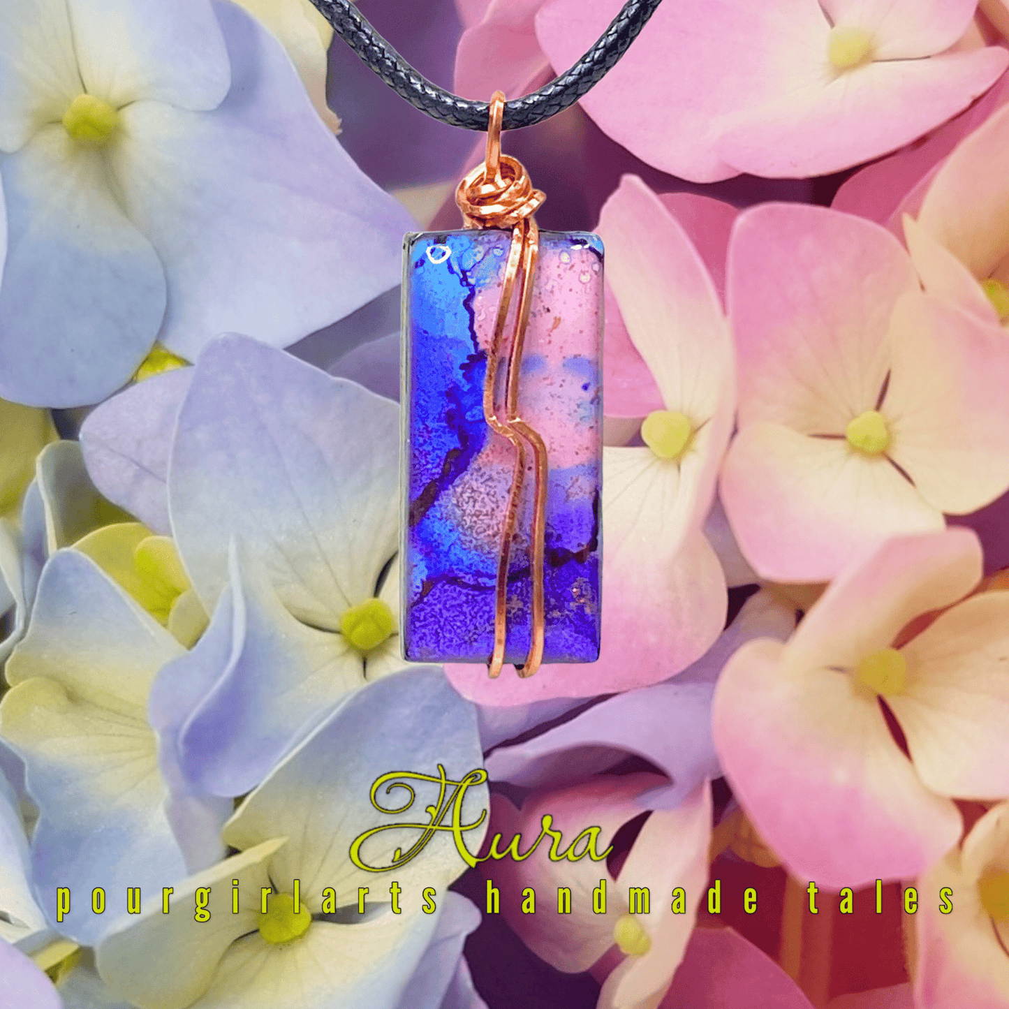 Necklace with a colorful pendant on a background of hydrangea flowers, featuring the brand 'Aura pourgirlarts handmade tales'.