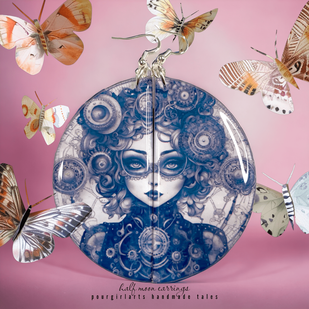 Decorative earrings with a face design surrounded by butterflies on a pink background