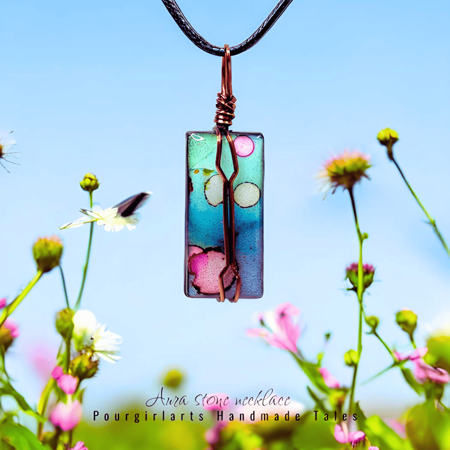 Colorful pendant necklace with floral design against a blue sky and flowers background