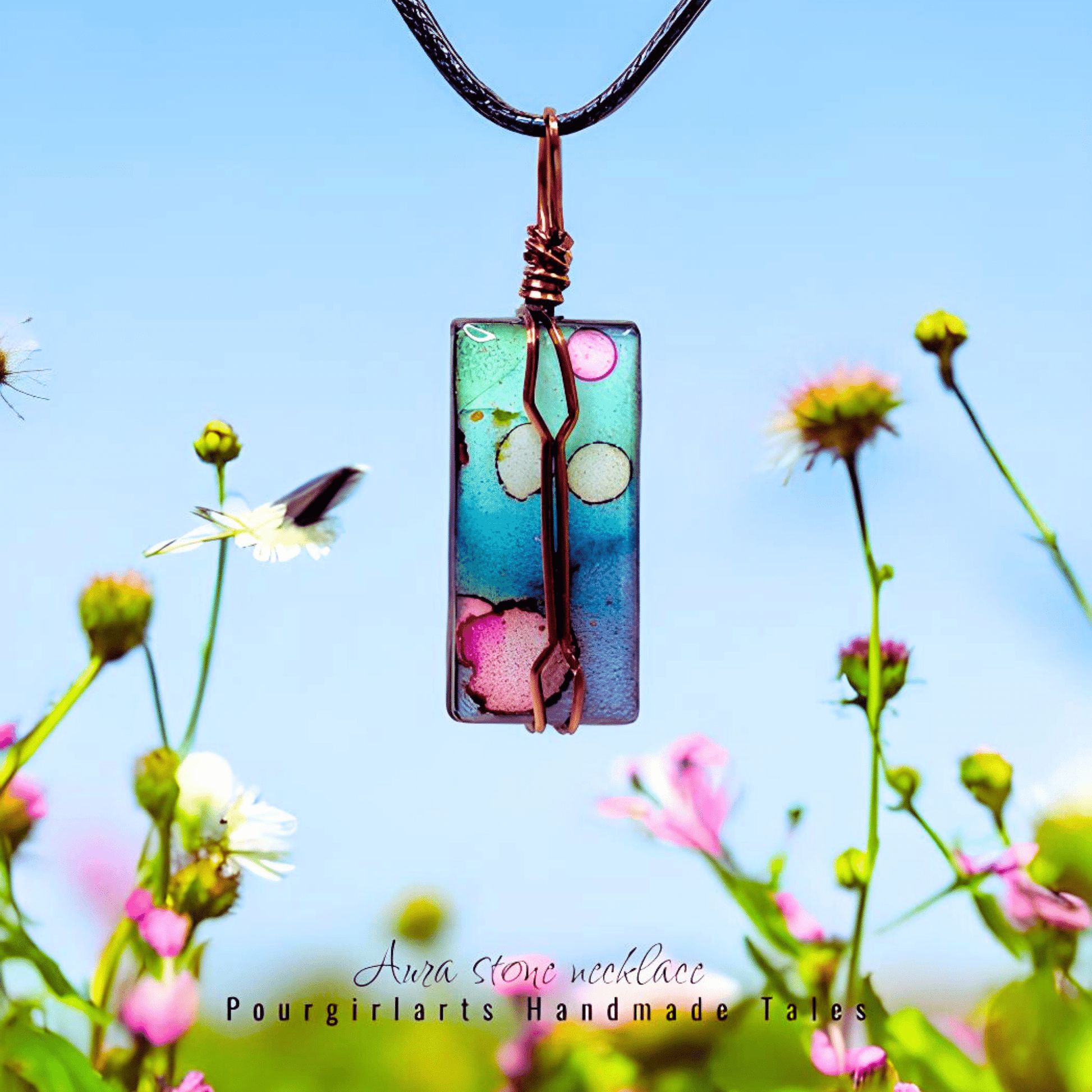 Colorful pendant necklace with floral design against a blue sky and flowers background
