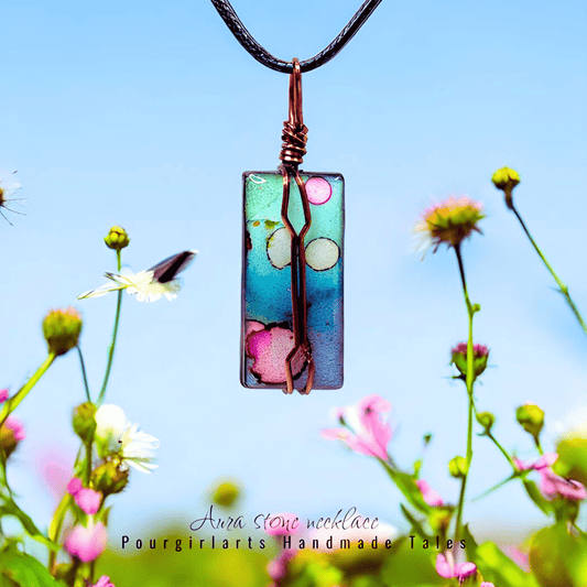 Colorful pendant necklace with floral design against a blue sky and flowers background